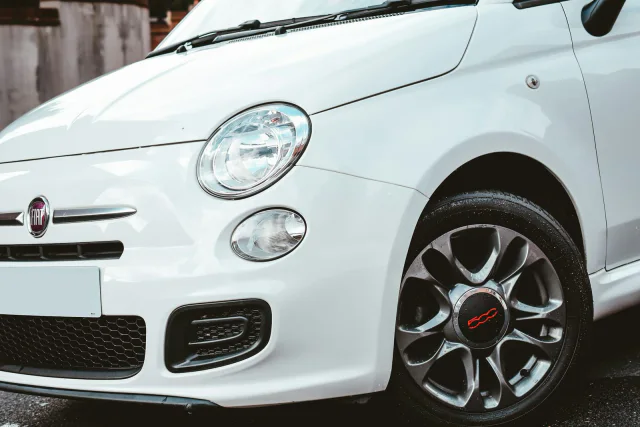 Biały Fiat 500, przód z reflektorem i felgą