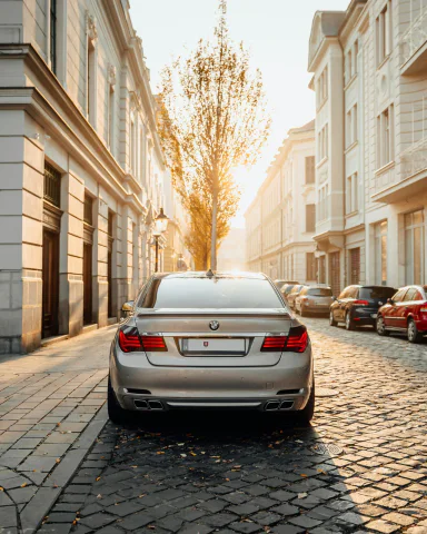 Srebrne BMW serii 7 na brukowanej ulicy, widok z tyłu