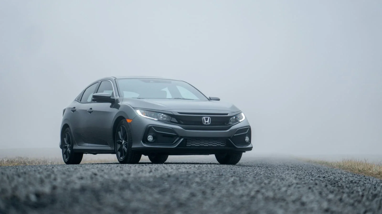 Szara Honda Civic sedan na drodze we mgle