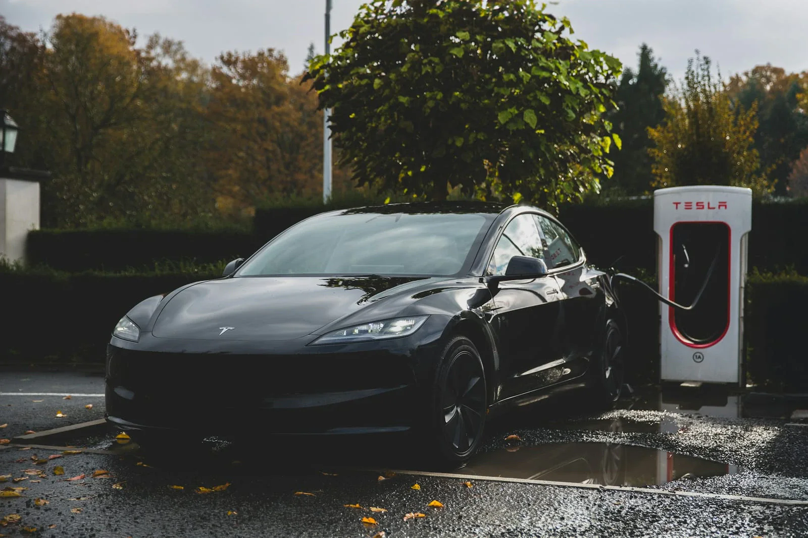 Black Tesla Model 3 charging at a Supercharger