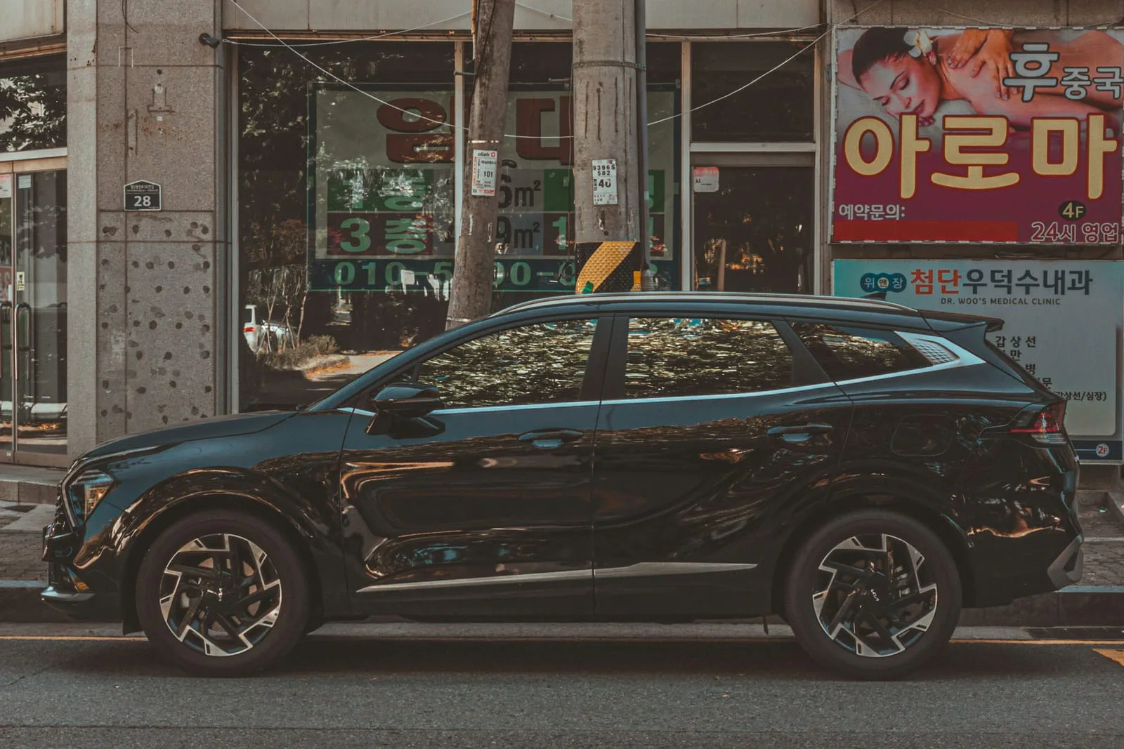 Чорна Kia Sportage збоку на міській вулиці